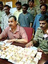 Police officials show the fake currency bundles