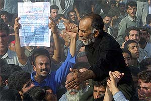 Dadollah Bijani, father of conjoined twins Ladan and Laleh Bijani, is carried during their funeral 