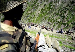 A security man keeps vigil as Amarnath pilgrims arrive at a camp in Jammu 