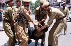 Policemen carry the body of a CRPF personnel who was killed by militants 