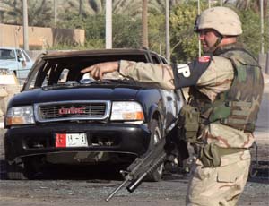 A US military policeman directs traffic in central Baghdad