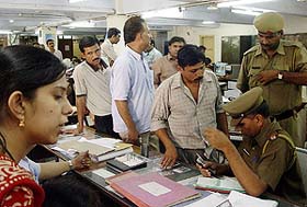 Police officials question employees after a cashbox containing about Rs 5.60 lakh was stolen from the LIC office in Ambala