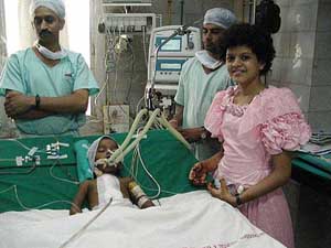 Palak Muchal, who sings to collect money for the treatment of deprived children, stands beside 2-year-old Varkha