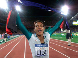 Cathy Freeman carries both the Aboriginal and Australian flags during a victory lap 