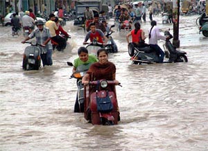People drag their vehicles through a pool of rain water in Amritsar