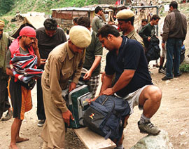 A policeman checks the baggage of an Amarnath pilgrim near Chandanwari