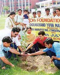 Members of the local unit of the Uttarakhand Yuva Manch plant a sapling at a camp held at Government High School