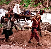 Four Kashmiri labourers, carrying an old pilgrim