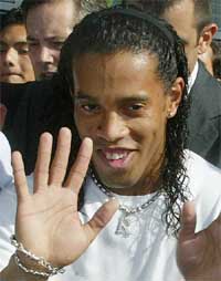 Brazilian soccer star Ronaldinho waves as he arrives at Barcelona�s airport