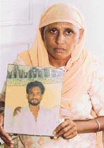 Gurpal Kaur holds the photograph of her husband, Balwant Singh, who was killed allegedly by some ‘influential’ villagers two years ago