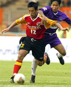East Bengal�s Baichung Bhutia struggles for the ball with Persita Club's Maman 