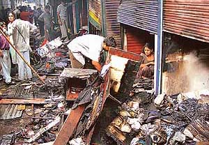 Shopkeepers of Janata Rehri Market, Mani Majra, look for their goods after a fire destroyed their shops in Chandigarh on Tuesday morning.