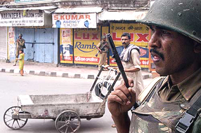 A Central Reserve Police Force personnel patrols a street during a strike in protest against the recent killings by militants, in Jammu on Wednesday.