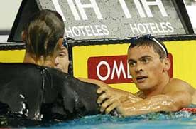 Gold medal winner Alexander Popov of Russia reaches out to third-placed Ian Thorpe