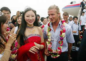 David Beckham being greeted by beauty queens