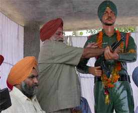 Mr Tej Parkash Singh, Transport Minister, Punjab, garlands the statue of Shaheed Major Singh, a Kargil martyr, after the unveiling ceremony at Lapran village