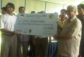 Jammu & Kashmir Chief Minister Mufti Mohammad Sayeed presents the winner's cheque to Kashmir Open golf champion Jyoti Randhawa