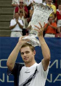 Andy Roddick of the US lifts the RCA championship trophy 