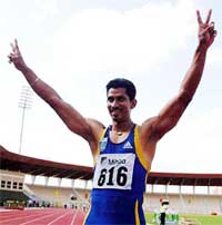 Sandeep Sarkaria of New Delhi flashes victory sign after winning the 100m race