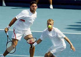 Australia's Lleyton Hewitt hits a volley as compatriot Mark Philippousis looks on