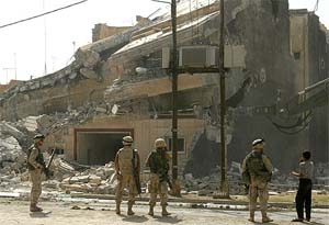 US soldiers patrol the house in which Saddam Hussein's sons, Uday and Qusay, were killed