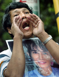 A Myanmar resident in Japan, clutching a portrait of Aung San Suu Kyi, shouts during a protest in front of the Myanmar Embassy in Tokyo