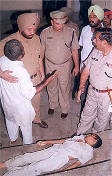 Gurpreet�s father Jinder Pal remonstrates with SSP P.S. Umranagal as Gurpreet lies dead on a stretcher in Patiala on Friday. 