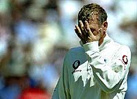 England wicket-keeper Alec Stewart holds his head as he leaves the field after being struck by a ball 