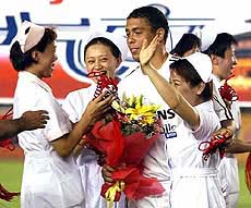 Real Madrid's Brazilian  striker Ronaldo receives gifts from Chinese nurses before their inaugural match of the Asian tour against the Dragon Team