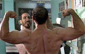 An Iraqi person looks at himself on a mirror at a Baghdad gymnasium