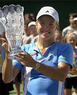 Justine Henin-Hardenne of Belgium lifts the winner�s trophy after defeating compatriot Kim Clijsters in the finals of the Acura Classic