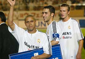 Real Madrid's Roberto Carlos shows his valuable player award as Raul Gonzalez and David Beckham look on
