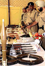 CRPF officers at a camp in Srinagar display arms and ammunition seized during anti-militant operations in the Kashmir valley 