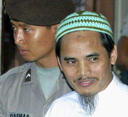 Bali bomb-blast suspect Amrozi arrives at a courthouse in Denpasar