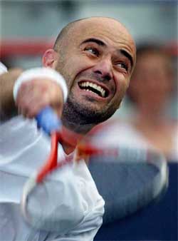 Andre Agassi of the US serves to Russia's Nikolay Davydenko