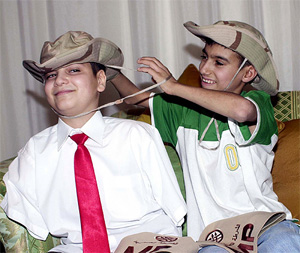 Thirteen-year-old Ali Ismaeel Abbas and Ahmed Mohammed Hamza, who lost a leg and a hand, play with US army hats