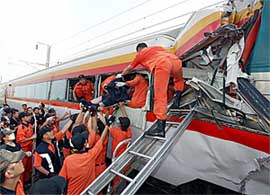South Korean firefighters work at the scene of a train accident in Taegu, about 320 km southeast of Seoul on Friday. At least two people were killed and about 48 injured when a passenger train crashed into a freight train.