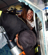A South Korean firefighter tries to rescue an injured woman from a crushed passenger coach at the scene of the train accident. 