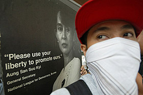 A Filipino protester stands beside a picture of National League for Democracy leader Aung San Suu Kyi during a protest outside the Burmese Embassy in Manila on Friday. Dozens of people held a protest on Friday to commemorate the 15th anniversary of the popular "Burma People's Uprising," known as the "8-8-88 event"