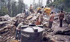 Labourers rummage through the debris