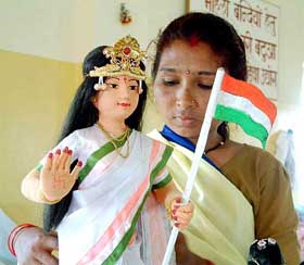 A woman inmate of Bhopal Central Jail decorates an idol of 'Bharat Mata' for the celebration of Independence Day programme at the jail premises