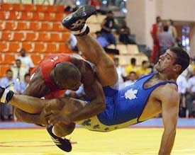 Canada's Carl Rainville is flipped by Yoel Romero of Cuba at the final of the men's 84-kg wrestling match 
