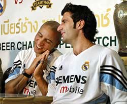 Real Madrid's Roberto Carlos and teammate Luis Figo put their hands together for a traditional Thai greeting