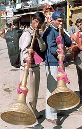 Devotees play 'Karnal', a traditional Himachali musical instrument, before starting their journey for Mani Mahesh