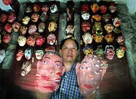 Taiwanese artist Wu Chih-chiang displays a pair of masks with multiple mouths and eyes 