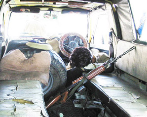 A policeman takes a nap while his weapon lies  unattended at the backseat 