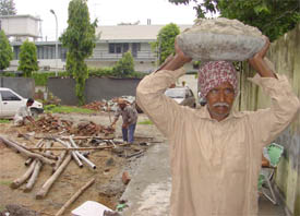 Sixty-year-old visually impaired Jagdish Yadav carries sand at a construction