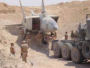 A US military search team uses a truck to tow a MiG-25R