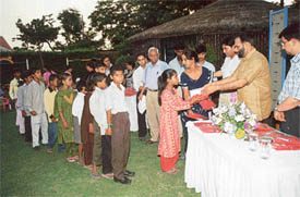 The Adviser to the Administrator, Mr Virendra Singh, distributes gifts to slum children of a night school