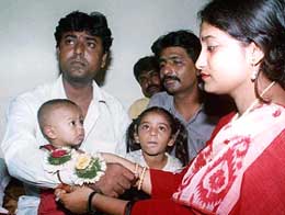 Dabasmita, a neighbour of Kutubuddin Ansari, ties a rakhi on his wrist in Kolkata